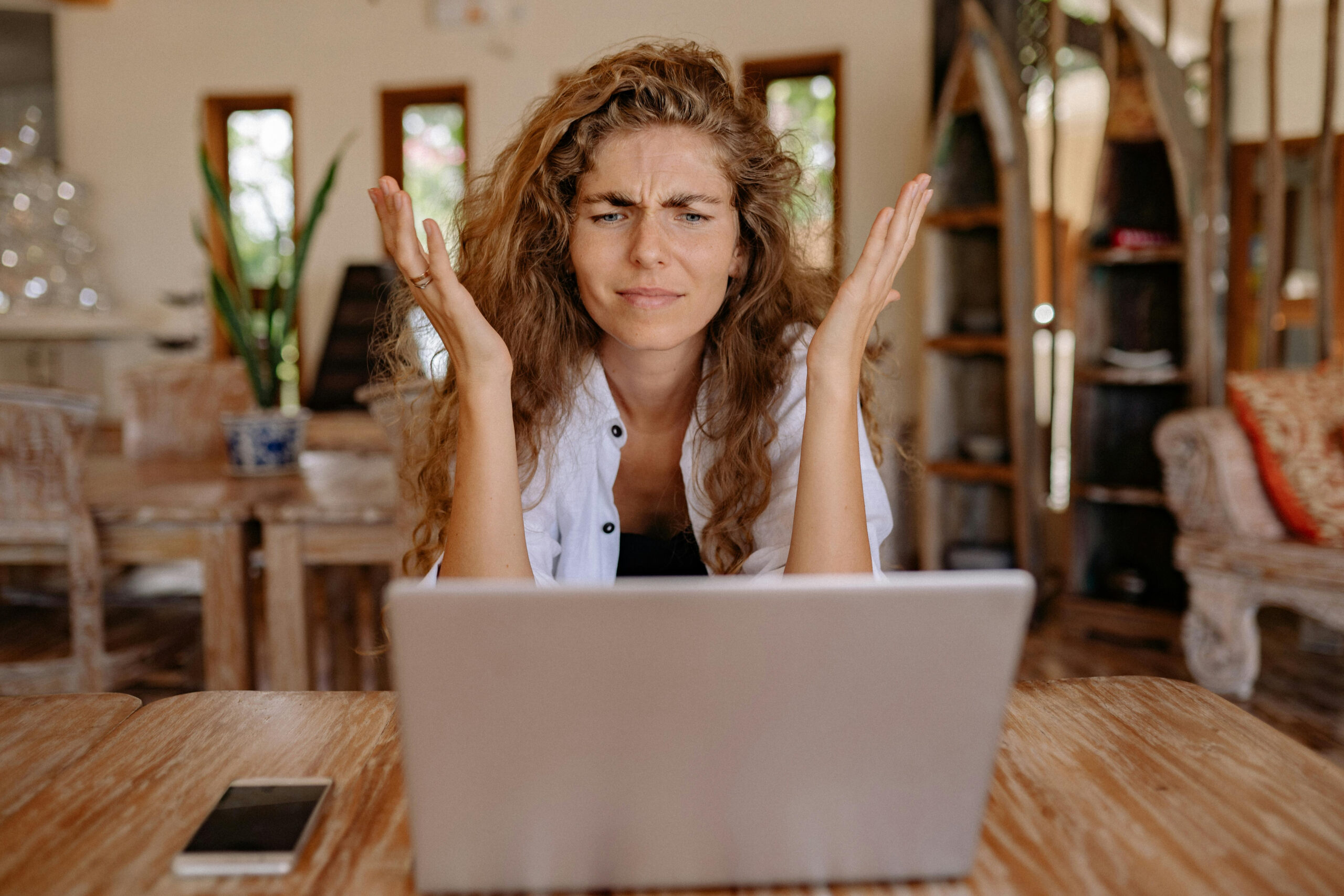 Frustrated woman sitting at a laptop with furrowed brow, symbolizing the stress of outgrowing business systems.