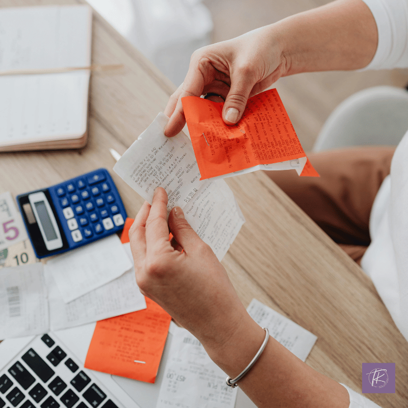 Business owner reviewing receipts by hand with a calculator and laptop nearby, symbolizing the hidden impact of unmanaged business expenses.