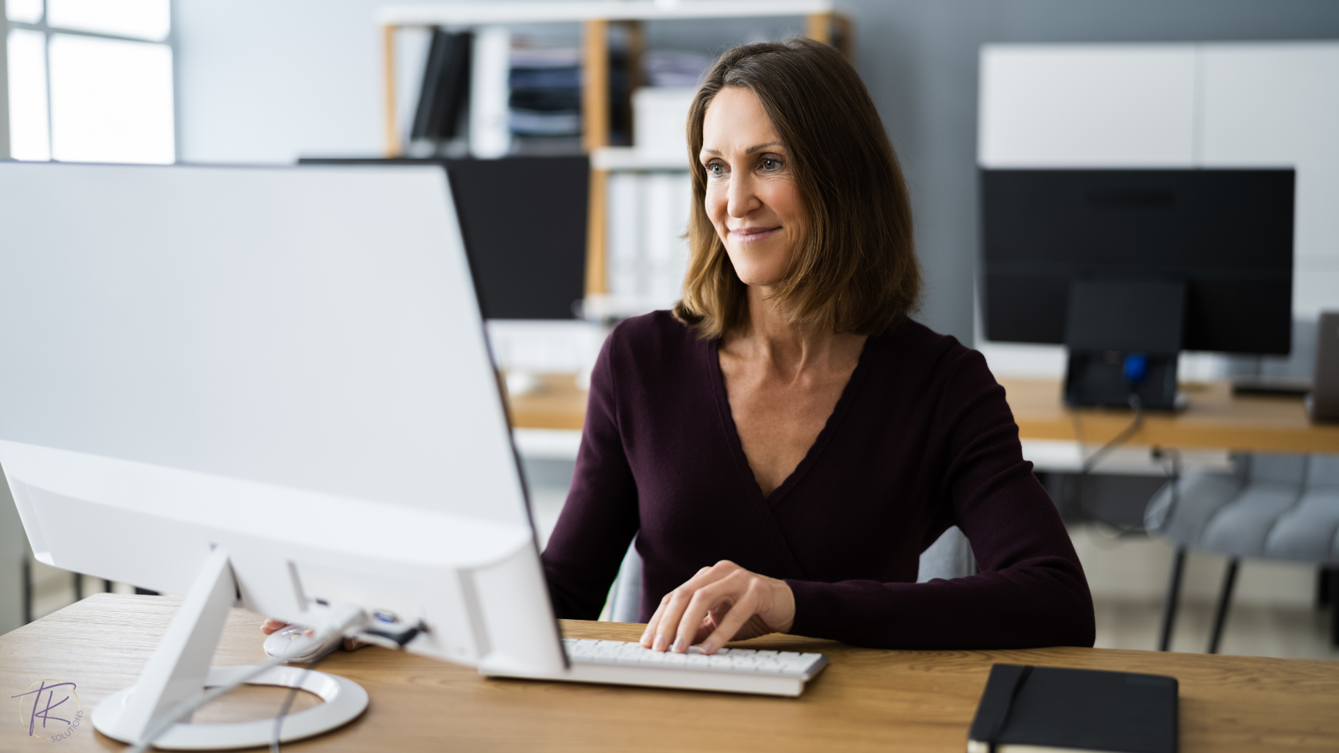 Woman business owner reviewing financial data with confidence at her desk